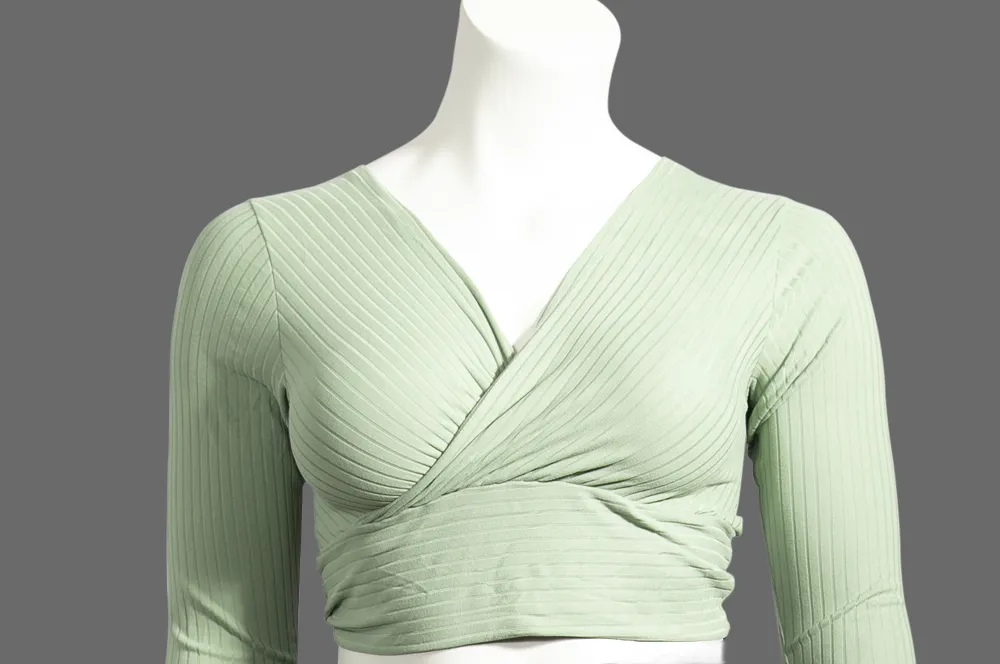 A green jacket on a white mannequin, showing the 'before' image for a 3D/360° packshot ghost mannequin effect.